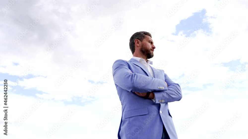 Serious ambitious employee in formal suit keep arms crossed on sky, ambition Serious ambitious employee in formal suit keep arms crossed on sky, ambition