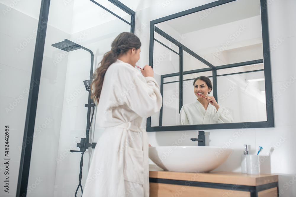 A picture of a young woman in a bathrobe in the bathroom A picture of a young woman in a bathrobe in the bathroom