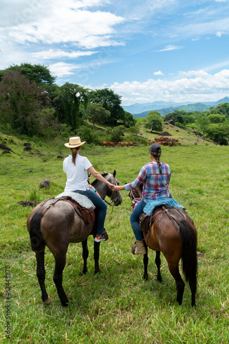 couple of friends on a horseback ride looking at the landscape. Tamesis, Antioquia, Colombia.