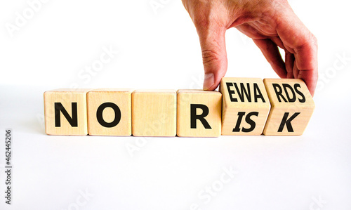 No risk and rewards symbol. Businessman turns wooden cubes and changes words 'no risk' to 'no rewards'. Beautiful white background. No risk and rewards, business concept. Copy space.