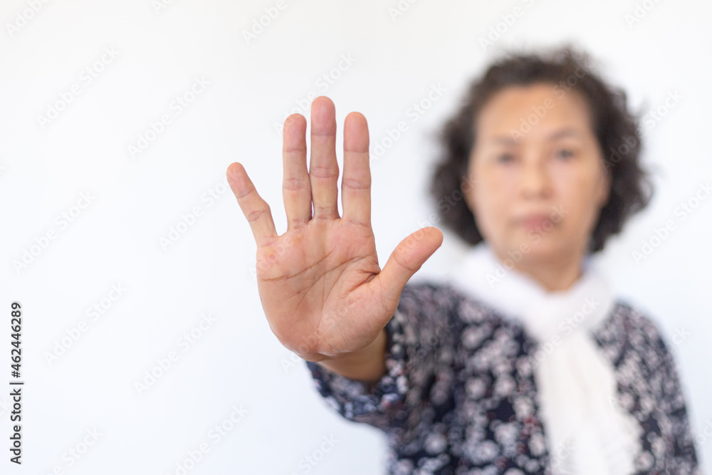 The portrait of an elderly woman showing stop sign over The portrait of an elderly woman showing stop sign over