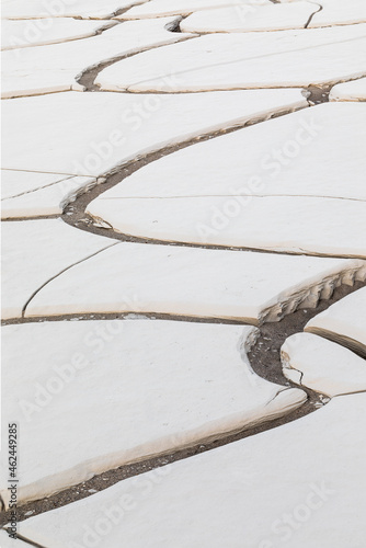 Mud cracks in former lake bed in the middle of a sand dune field in Death Valley National Park.