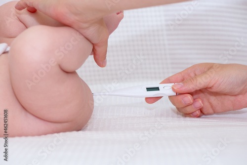 Hand of a woman taking rectal fever of a baby