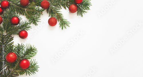 Christmas New Year greeting card template, Fresh fir twig and red baubles on white color background.