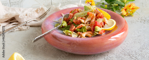 salad plate with avocado, concasse tomatoes and crayfish tails on the table photo