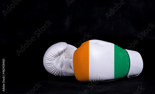 Boxing glove with Code d Ivoire flag on black background photo