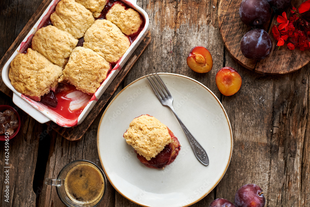 Naklejka premium Plum cobbler on a wooden background.