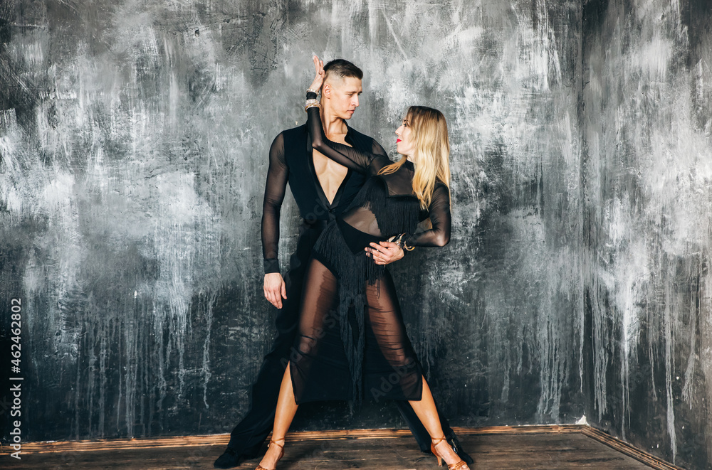 Couple of two professional ballroom dancers is dancing on loft studio. Beautiful art performance. Sport life concept. Passion and emotional dance.
