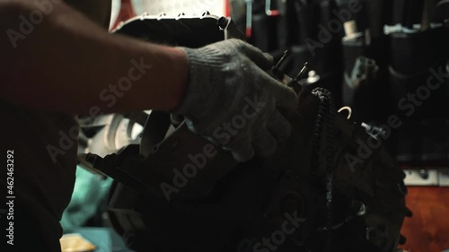 a man in work gloves installs a variator box on an ATV engine
