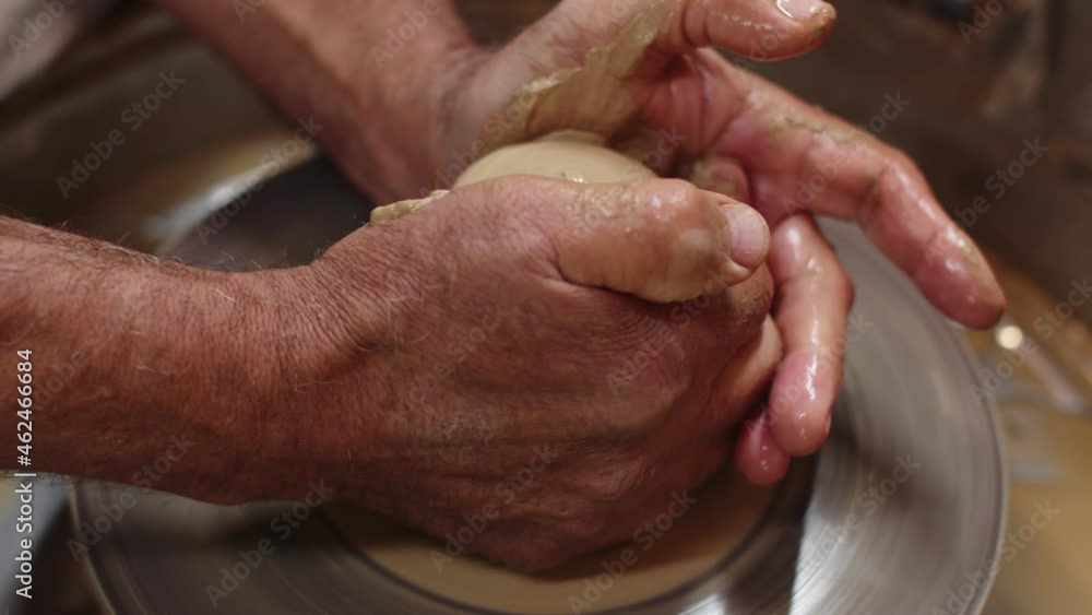 Male hands of potter prepares ceramic product for sale, closeup. Man is engaged hobby in his workshop. Craftsman process piece of clay on potters wheel. Concept hobby Male hands of potter prepares ceramic product for sale, closeup. Man is engaged hobby in his workshop. Craftsman process piece of clay on potters wheel. Concept hobby