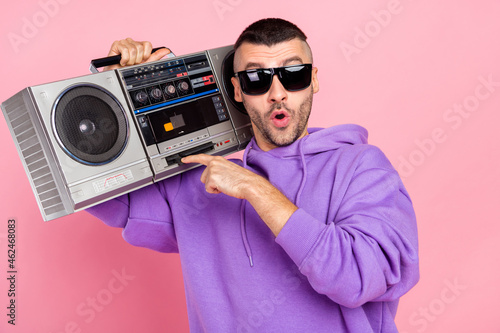 Photo of impressed millennial brunet guy listen boom box wear eyewear hoodie isolated on pink background