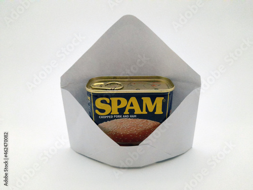 An envelope with spam in it, not digital spam but the canned ham type of spam symbolizing unwanted junk in your e-mail. photo
