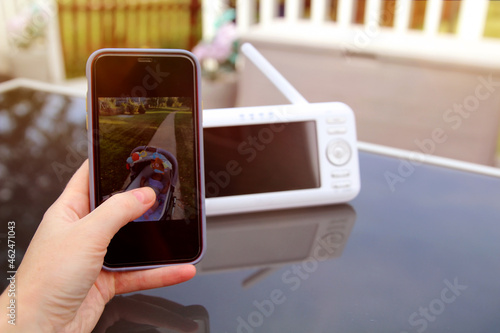 Foto Woman  is checking the  phone and  baby monitor for security of the baby