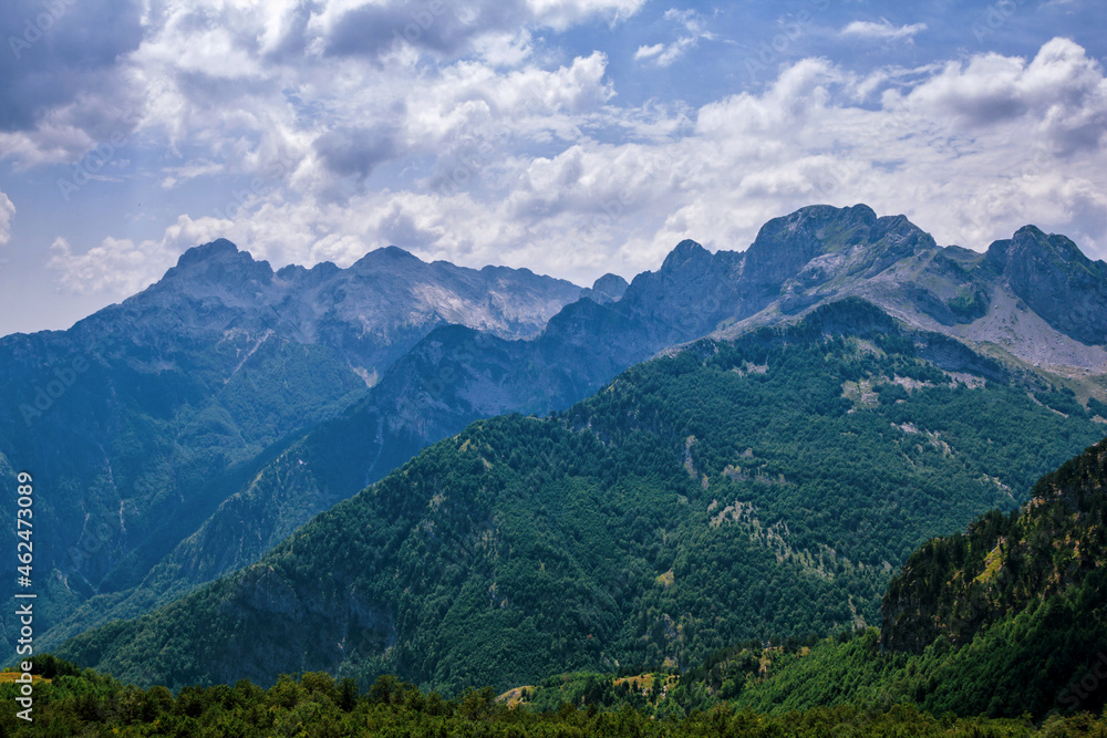 Summer landscape - Albanian mountains, covered with green trees and blue sky with white clouds