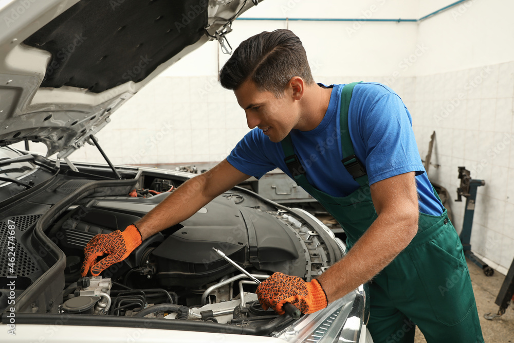 Professional mechanic fixing modern car at automobile repair shop Professional mechanic fixing modern car at automobile repair shop