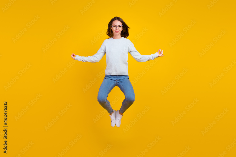 Full body photo of happy calm young woman jump wear glasses asana isolated on yellow color background