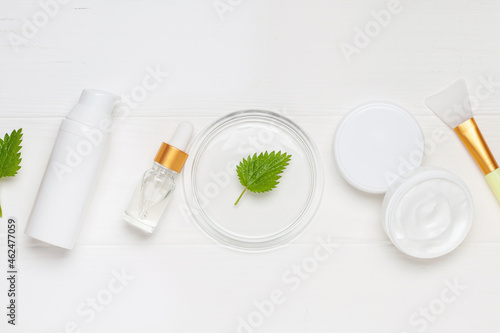 Natural cosmetics with nettle leaves. Top view. Cream, serum, bottle lotion.