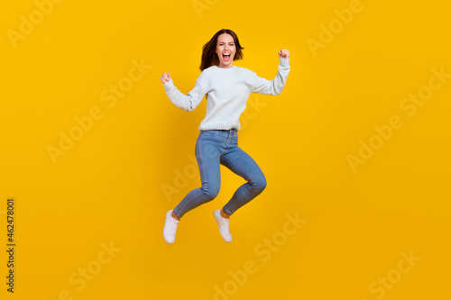 Full body photo of cheerful crazy happy woman jump up winner sale news isolated on yellow color background
