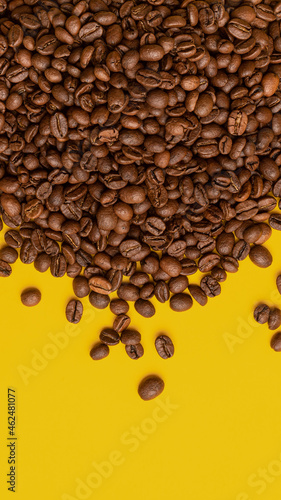 coffee beans on a yellow background  other grains scattered around  concept
