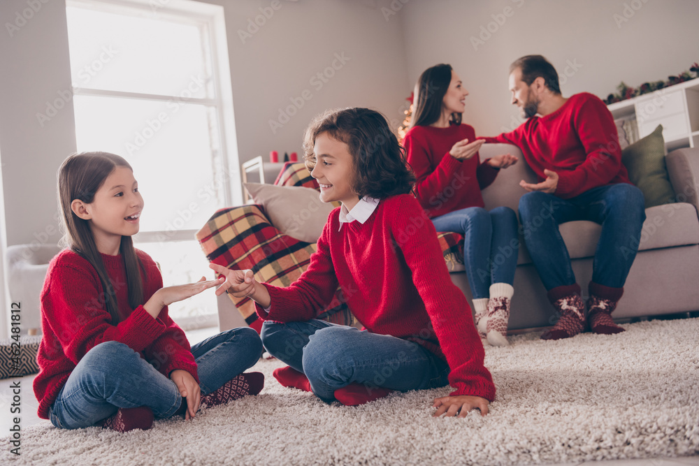 Photo of charming attractive dad mom two children dressed red sweaters talking playing game smiling indoors room home house Photo of charming attractive dad mom two children dressed red sweaters talking playing game smiling indoors room home house