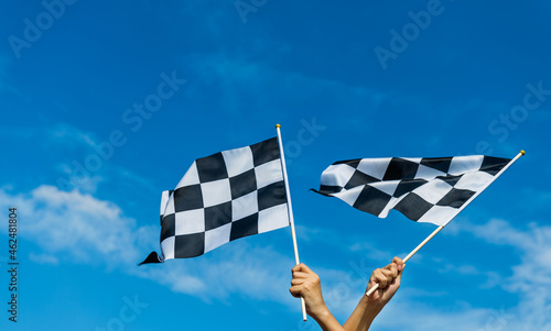 Hand holding checkered race flag in the air © xy
