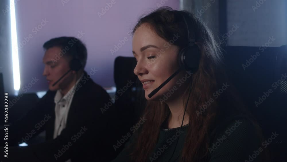 Technical Support Specialist With Headsets Working On Computer In Call Center Control Room Answers Incoming Calls Talk With Client Gives Professional Consultation To Customers Sell Company Product. Technical Support Specialist With Headsets Working On Computer In Call Center Control Room Answers Incoming Calls Talk With Client Gives Professional Consultation To Customers Sell Company Product.