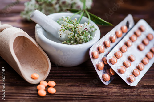 Valerian tablets in a yellow shell in blister pack. light sedative and hypnotic. natural cure for insomnia, anxiety, stress and to promote appetite photo