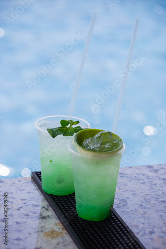 Cocktail on a table a pool in the background