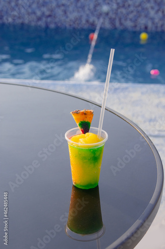 cocktail on a glass table and a pool in the background
