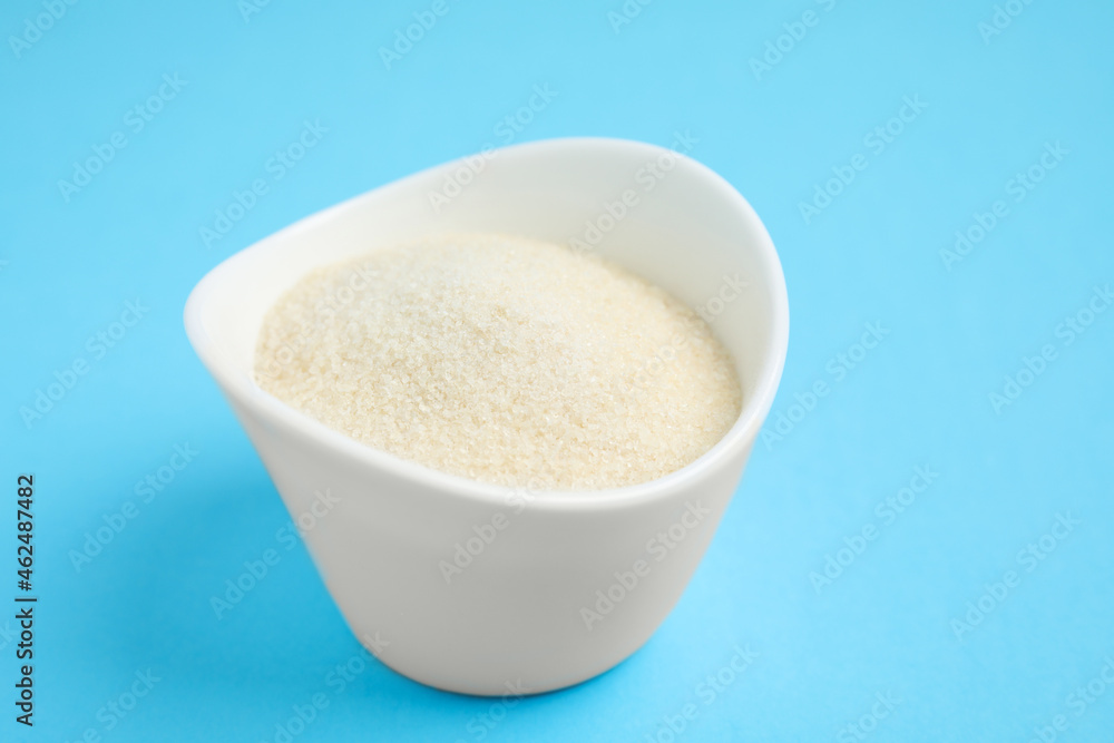 Gelatin powder in bowl on light blue background, closeup Gelatin powder in bowl on light blue background, closeup