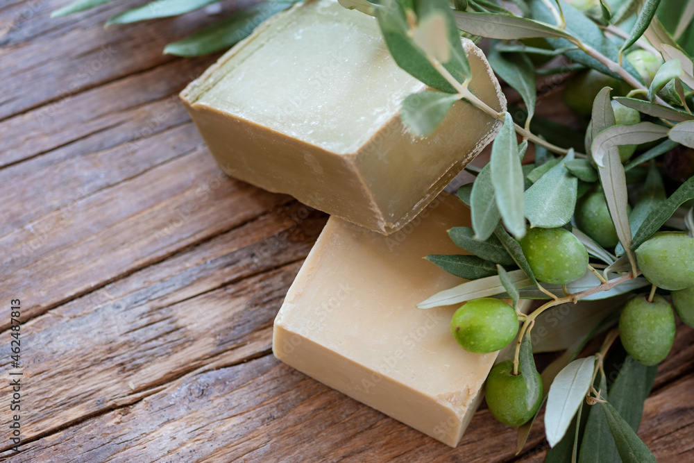 Handmade soap bars and olive branches on wooden background, beauty treatment ,top view copy space. Handmade soap bars and olive branches on wooden background, beauty treatment ,top view copy space.