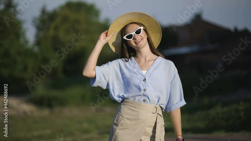 young woman with white sunglasses and hat