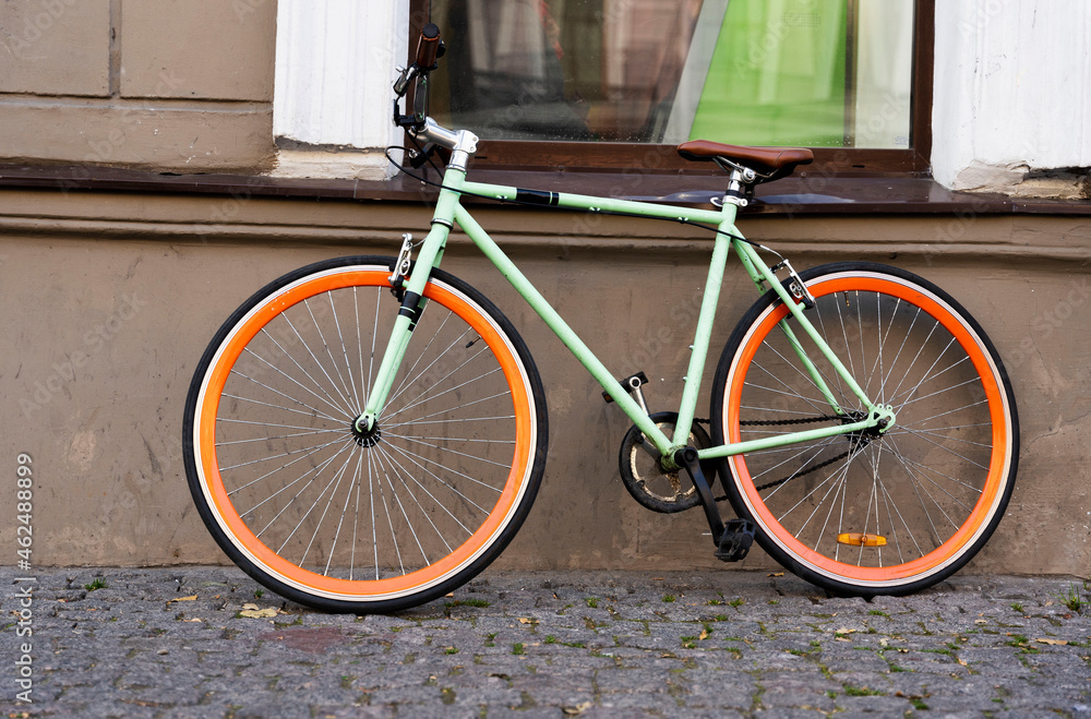 A city bike parked against the wall of a cafe in the city, Cycling to work, a stylish bike in an urban environment