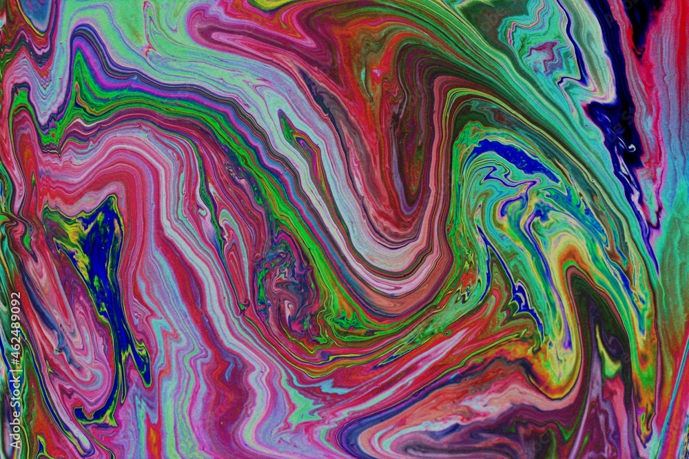 Abstract multicolored marble background. Acrylic paint mixes freely and creates an interesting pattern. Bright saturated shades. Background for the cover of a laptop, laptop.