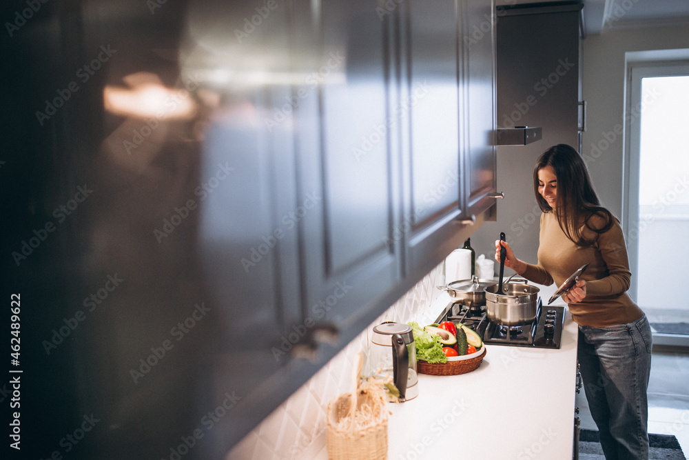 Woman cooking soup at kitchen