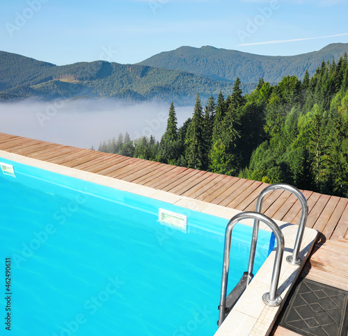 Outdoor swimming pool at luxury resort and beautiful view of mountains on sunny day © New Africa