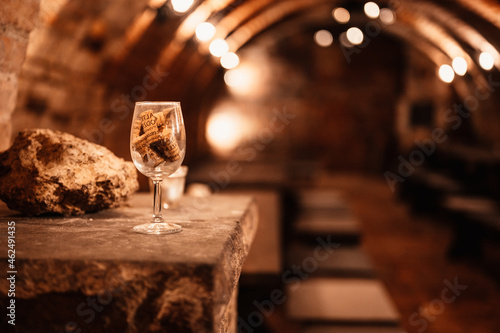 Old wine bottles dusting in an underground tratitional cellar. Small and old wine cellar with full wine bottles. Winery concept. Valtice Castle in South Moravia, Czech Republic, Europe photo