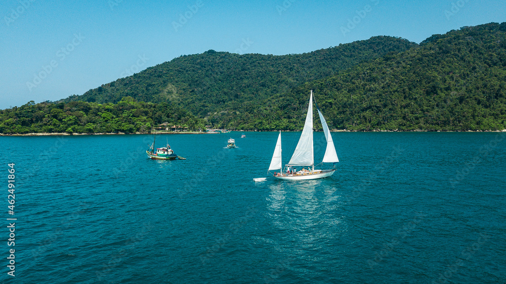 Obraz premium Beautiful classic sailboat sailing through the Paraty Bay, Rio de Janeiro, Brazil.