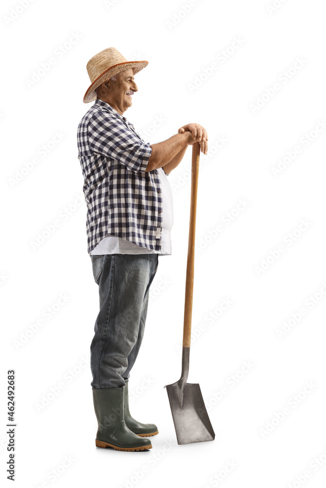 Full length profile shot of a mature farmer standing with a shovel Full length profile shot of a mature farmer standing with a shovel