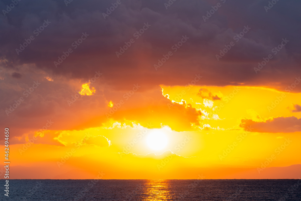 Stunning dramatic, cloudy sunrise with a bright sun rising over a calm water. Natural background, Sardinia, Italy. Stunning dramatic, cloudy sunrise with a bright sun rising over a calm water. Natural background, Sardinia, Italy.