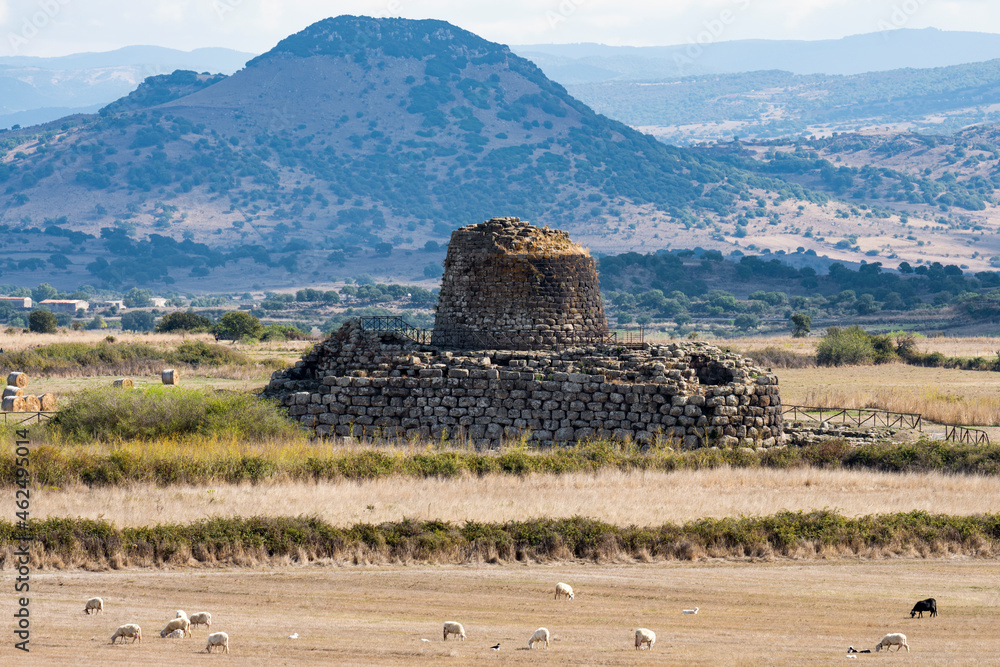 Stunning landscape with the ancient Santu Antine Nuraghe and some sheep grazing in the foreground. Santu Antine Nuraghe is one of the largest Nuraghi in Sardinia, Italy.