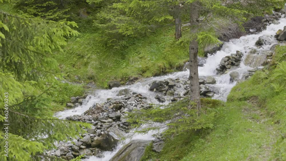 Water flowing around stones. Creek in the mountains. Schächental valley, Canton Uri, Switzerland. Water flowing around stones. Creek in the mountains. Schächental valley, Canton Uri, Switzerland.