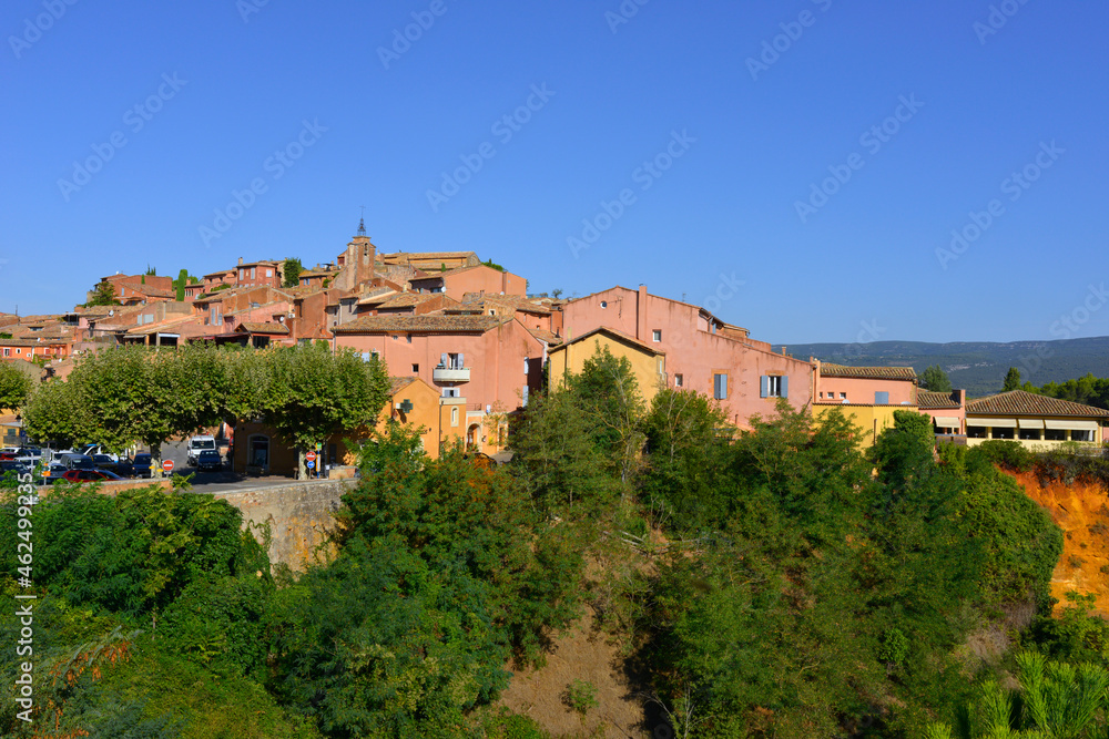 Roussillon (84220) habillé de rose entre ciel bleu et nature, département du Vaucluse en région Provence-Alpes-Côte-d'Azur, France