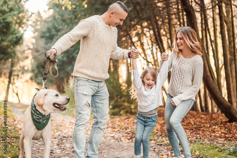 Happy beautiful family with dog labrador is having fun together walking the in park. Happy beautiful family with dog labrador is having fun together walking the in park.