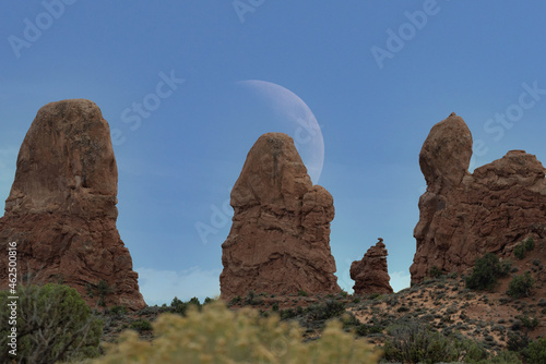 Telephoto landscape of moon over rock formations in the beautiful American southwest desert of Arches National Park, Utah