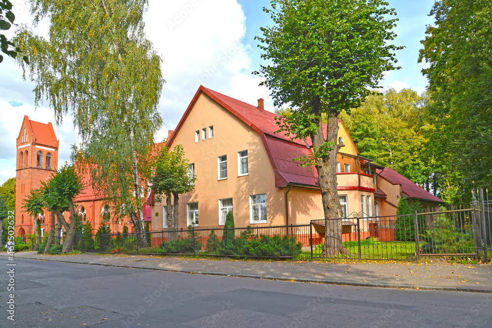 A German-built residential building (1910) and a fragment of the building of the church of the suburb of Ponart. Marshal Novikov Street, Kaliningrad