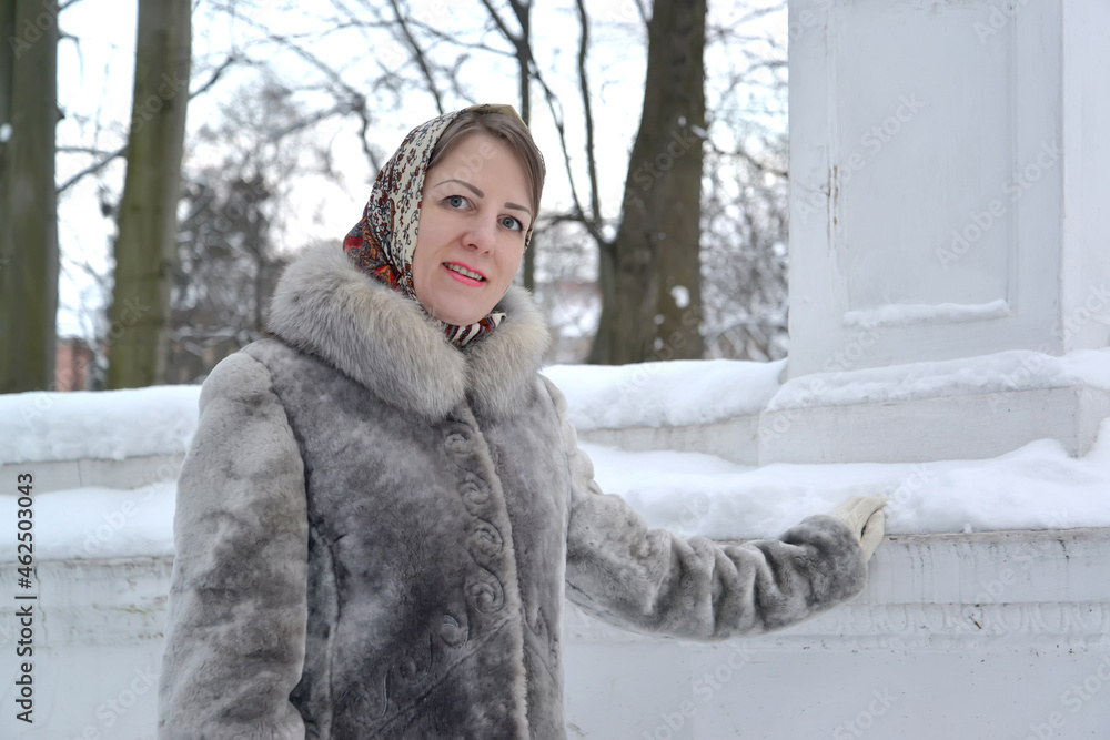 Portrait of a young woman in a fur coat and a head scarf in the winter Portrait of a young woman in a fur coat and a head scarf in the winter