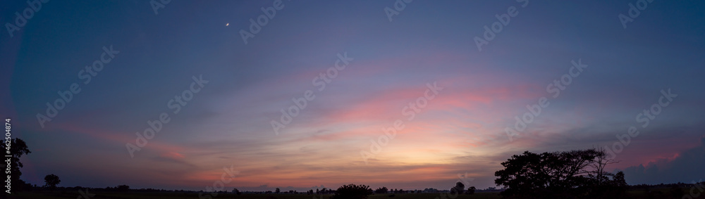 panoramic view of beautiful sunset with half moon on twilight sky and colorful cloud