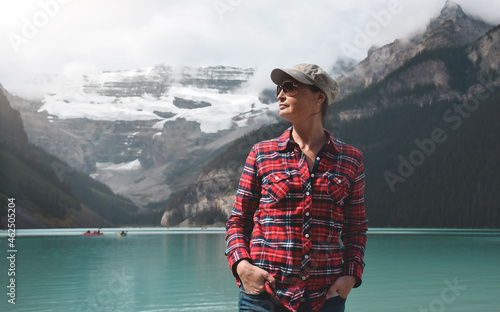 Portrait of woman in red shirt with lake and mountains behind her photo