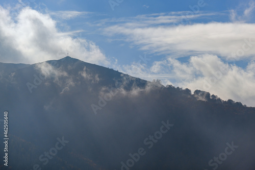 Morning foggy clouds in sunlight and autumn mountain countryside. Ukraine, Carpathian Mountains, Borzhava Range, Transcarpathia.